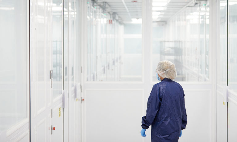Person in PPE in ISO cleanroom in reagents manufacturing facility
