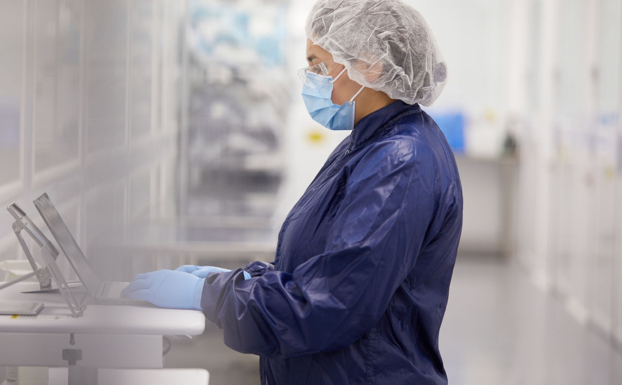 Woman in PPE working on a computer