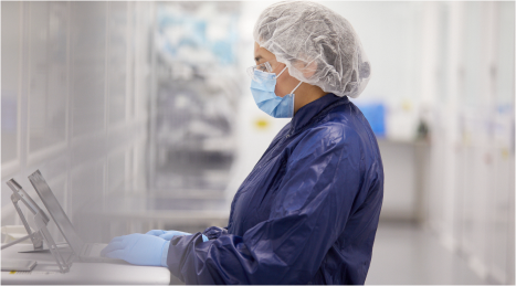 Woman in PPE working on laptop