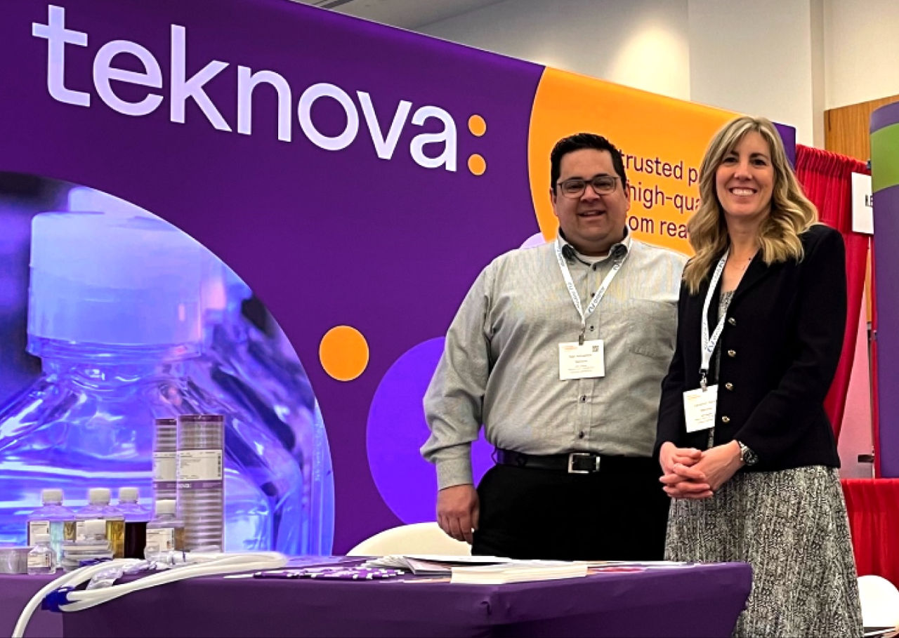 Members of the teknova team standing at a booth at a conference